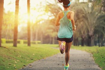 Healthy young sporty woman running on a park trail at sunrise. at Renaissance Park Apartments, Davis